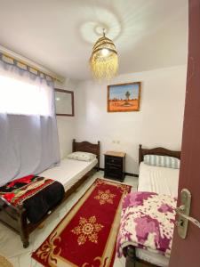 a bedroom with two beds and a chandelier at Dallas Private Surf Apartment in Agadir