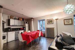 eine Küche und ein Esszimmer mit einem roten Tisch und Stühlen in der Unterkunft Gîte des Remparts in Besse-et-Saint-Anastaise