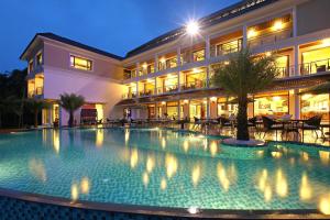a large swimming pool in front of a building at Lake Palace Trivandrum in Vettutura