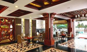 een restaurant met tafels en stoelen en een zwembad bij Lake Palace Trivandrum in Vettutura