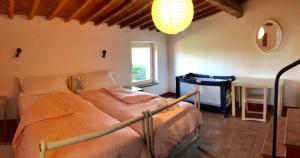 a bedroom with two beds in a room with a lamp at La Casa Rossa in Marina di Bibbona