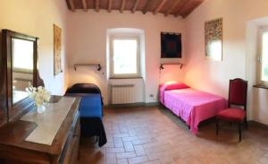 a bedroom with a bed and a table and chairs at La Casa Rossa 2 in Marina di Bibbona