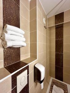 a bathroom with a shower and a toilet and towels at Kyriad Hotel Montpellier Centre Antigone in Montpellier