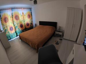 una camera da letto con un letto e una finestra con una tenda di HANA Apartament a Târgu-Mureş