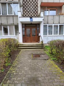 un edificio con una porta di legno di fronte di HANA Apartament a Târgu-Mureş