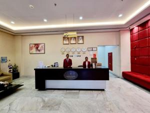 two people standing at a counter in a lobby at Aspire Tower - One Bedroom Solo Haven Juffair in Manama +27 photos