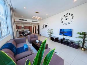a living room with a couch and a clock on the wall at Aspire TowerTwo Bedroom Pilot Paradise in Manama