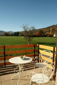 einen Tisch und Stühle auf einer Terrasse mit einem Feld in der Unterkunft Apartment Au Calme in Munster