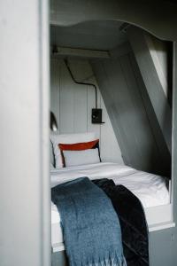 un letto bianco con una coperta blu sopra di Molen den Bonk a Lexmond