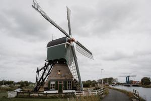 a windmill on the side of a river at Molen den Bonk in Lexmond