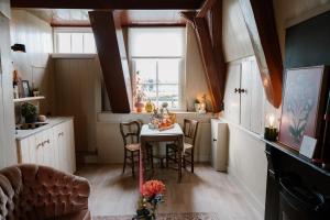 a kitchen with a table with chairs and a window at Molen den Bonk in Lexmond