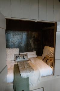 un letto con lenzuola bianche e cuscini sopra di Molen den Bonk a Lexmond