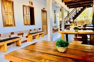 a room with a wooden table and benches at Pousada Salinas de Atins in Atins