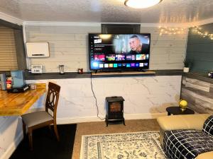 un soggiorno con una TV a schermo piatto su una parete di THE HIDEOUT 2pm Checkout a Moorhead