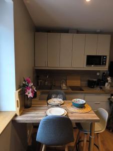 a kitchen with a wooden table with two chairs and a tableasteryasteryasteryastery at 2 Pièces Cozy Place Morny refait à neuf in Deauville +2 photos