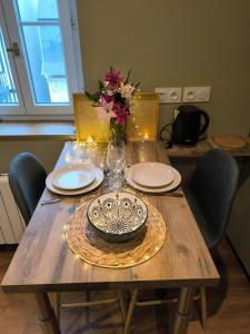 a wooden table with a vase of flowers on top of it at 2 Pièces Cozy Place Morny refait à neuf in Deauville