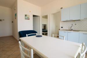 a kitchen with white cabinets and a table and chairs at 14 Trilocale fronte mare Evangelisti Casa in Bellaria-Igea Marina