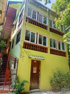 een geel huis met een balkon erbovenop bij Swahili apartelle in Boracay