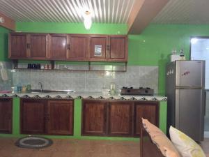 een keuken met houten kasten en een koelkast bij Swahili apartelle in Boracay +5 foto's