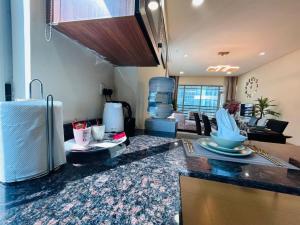 a kitchen with a counter top and a living room at Aspire Tower-Two Bedroom Urban Haven Juffair in Manama
