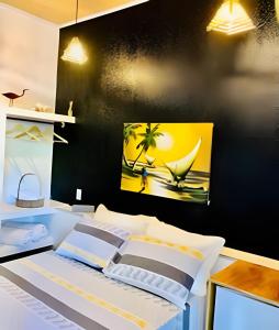a bedroom with a bed with a painting on the wall at Pousada Salinas de Atins in Atins