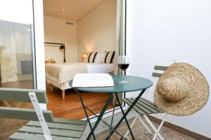 a room with a table with a glass of wine at Green Essence Duplex in Faro by Misha's Place in Faro