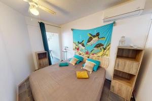 una camera da letto con un letto grande con un dipinto sul muro di Appartement face à la mer 2 chambres a Le Diamant