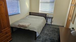 a small bedroom with a bed and a table at Convenient En-suite Double in Oxford
