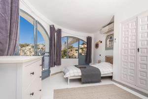 ein Schlafzimmer mit einem Bett und einem Fenster in der Unterkunft Beautiful Casa au Lilas Rosa, Benissa Costa in Benissa + 68 Fotos