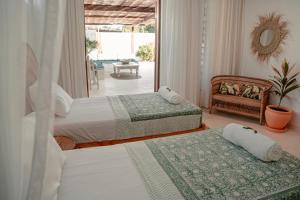 a bedroom with two beds and a chair at Eden Escapes - Diani Beach, Kenya in Diani Beach +134 photos