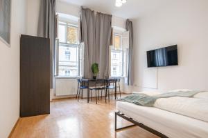 维也纳Amazing 2BR Shared Apt Only 7 Min to Wiener Stadthalle的一间卧室，配有一张床、一张桌子和几把椅子