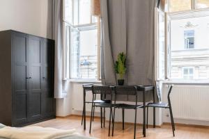 维也纳Amazing 2BR Shared Apt Only 7 Min to Wiener Stadthalle的一间带桌椅和2扇窗户的用餐室 更多12张照片