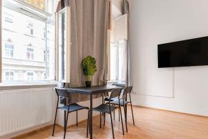 维也纳Amazing 2BR Shared Apt Only 7 Min to Wiener Stadthalle的一间有桌椅和电视的餐厅