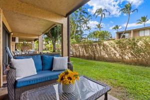 基黑Charming Tropical Kihei Gardens 2-Bed Suite - New的一个带蓝色沙发和玻璃桌的门廊