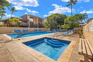 基黑Charming Tropical Kihei Gardens 2-Bed Suite - New的一个带蓝色椅子的游泳池和一栋建筑