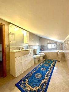 ein Badezimmer mit einem Waschbecken, einem WC und einem Teppich in der Unterkunft Quarto em casa em Bragança, Parque eixo Atlântico in Bragança + 1 Foto