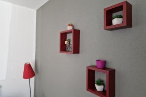 two red shelves on a wall with plants in them at Appartement avec vue sur le lac de Gérardmer, proche des pistes de ski in Gérardmer