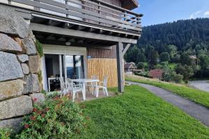 a table and chairs on the side of a house at Appartement avec vue sur le lac de Gérardmer, proche des pistes de ski in Gérardmer