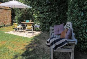a patio with a table and chairs and an umbrella at Landford's Cottage, your retreat! in Landford +42 photos