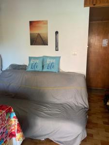 a bed with blue pillows on top of it at Slyre in Cap d'Agde
