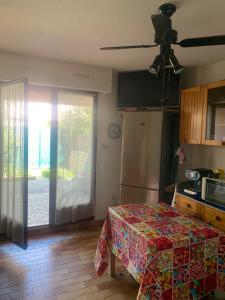 a kitchen with a refrigerator and a door to a yard at Slyre in Cap d'Agde