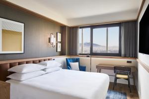 a hotel room with a bed and a desk and a window at Four Points by Sheraton Barcelona Airport in Barcelona