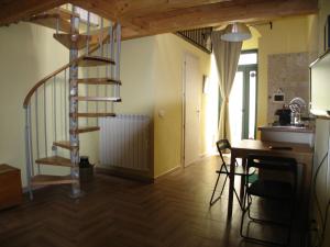 a spiral staircase in a room with a table and chairs at Pozzo Luce in Palazzolo Acreide