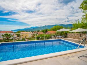 basen w hotelu z górami w tle w obiekcie Holiday Home Koalas Nest Home & Apartments by Interhome w mieście Matulji