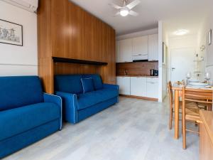 a living room with a blue couch and a table at Apartment AcquadiMare by Interhome in Sanremo