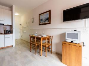 a kitchen with a table and a tv on a wall at Apartment AcquadiMare by Interhome in Sanremo