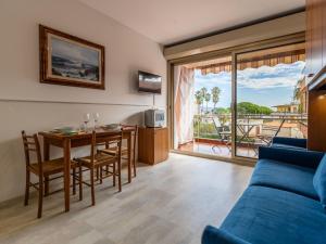 a living room with a blue couch and a table at Apartment AcquadiMare by Interhome in Sanremo +22 photos