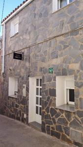un edificio de piedra con dos puertas blancas. en Casa rural Foreset, en Alfara de Carles