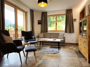 a living room with a couch and a table and chairs at Apartment Home Holzwurm by Interhome in See +30 photos