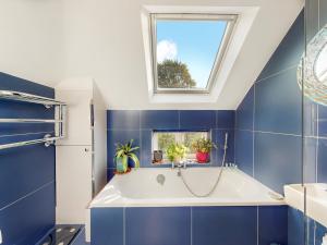 a bathroom with a tub and a window at Pass the Keys Elegant flat in trendy Hampstead in London